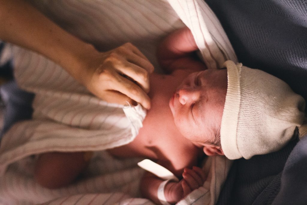 Neugeborenes Baby in einer Mütze