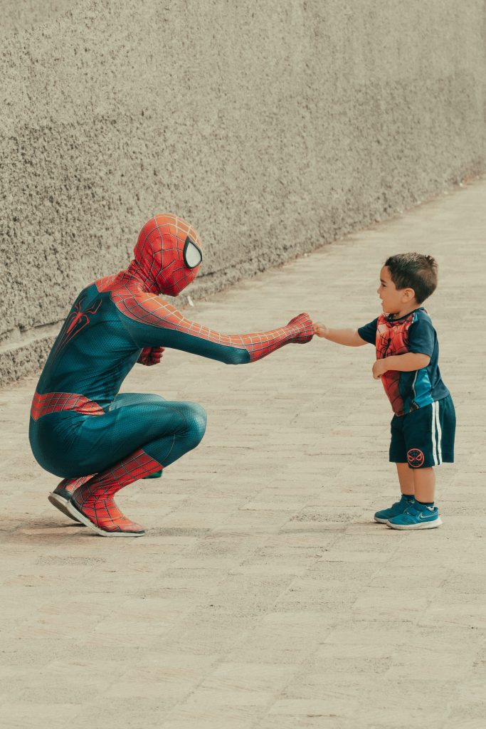 Ein man verkleidet wie ein Spiderman mit einem kleinen Jungen