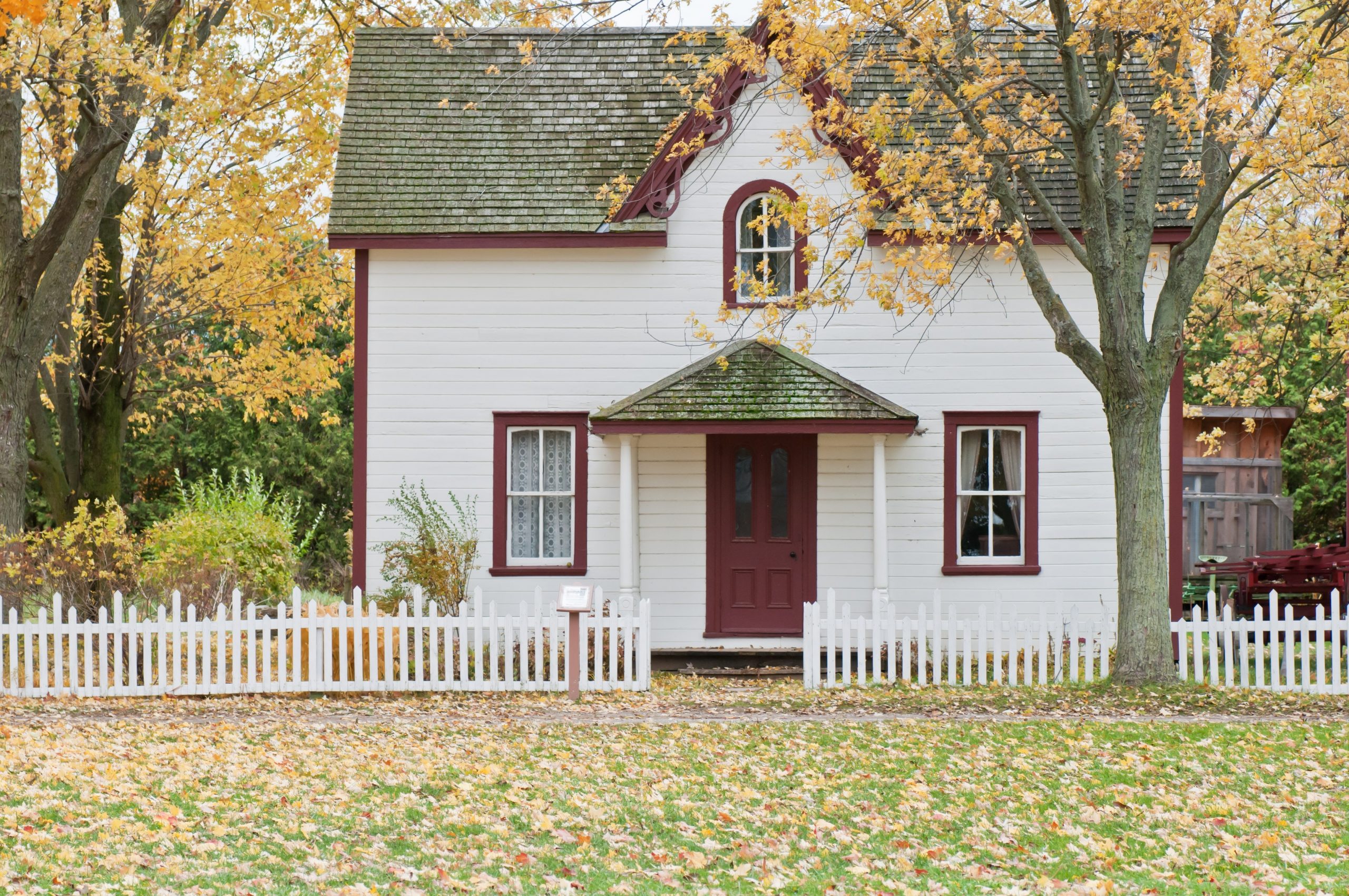 Weißes Haus im Herbstgarten